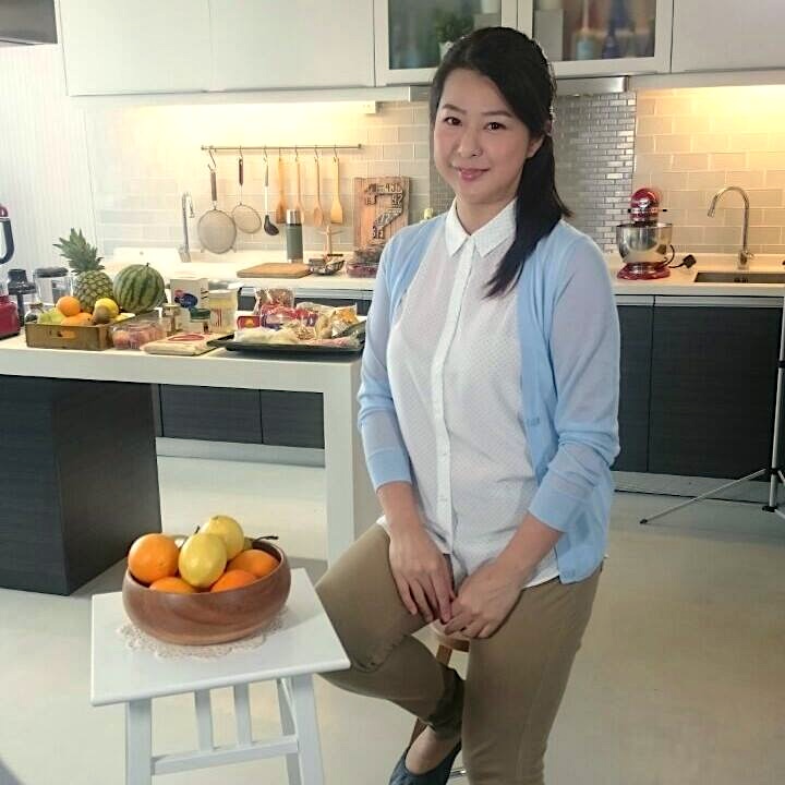 Bonnie sitting on the stool with fruit table setting, in front of the kitchen