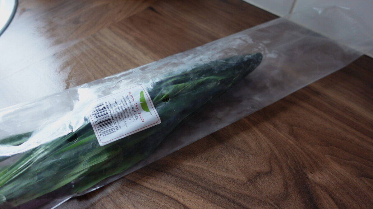 Frozen pandan leaves wrapped in plastic on a wooden kitchen counter
