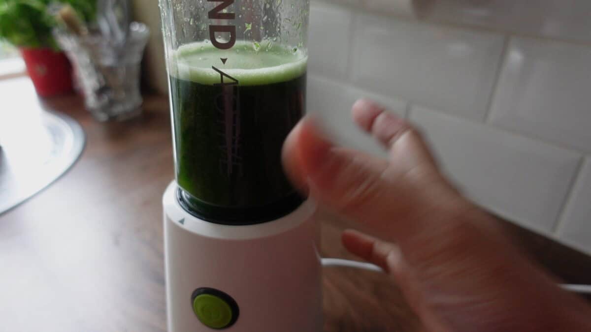 Blending fresh pandan leaves with hot water to make pandan juice