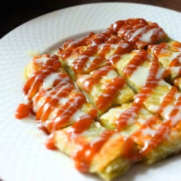Thai Banana Rotil, drizzled with caramel syrup & condensed milk, placed on the white plate